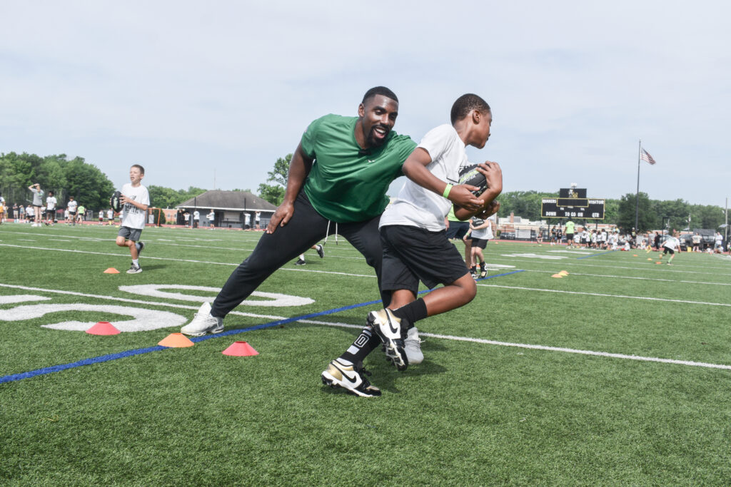Philadelphia Eagles defensive tackle Thomas Booker IV running a ball handling drill at Eagles Youth Football Academy
